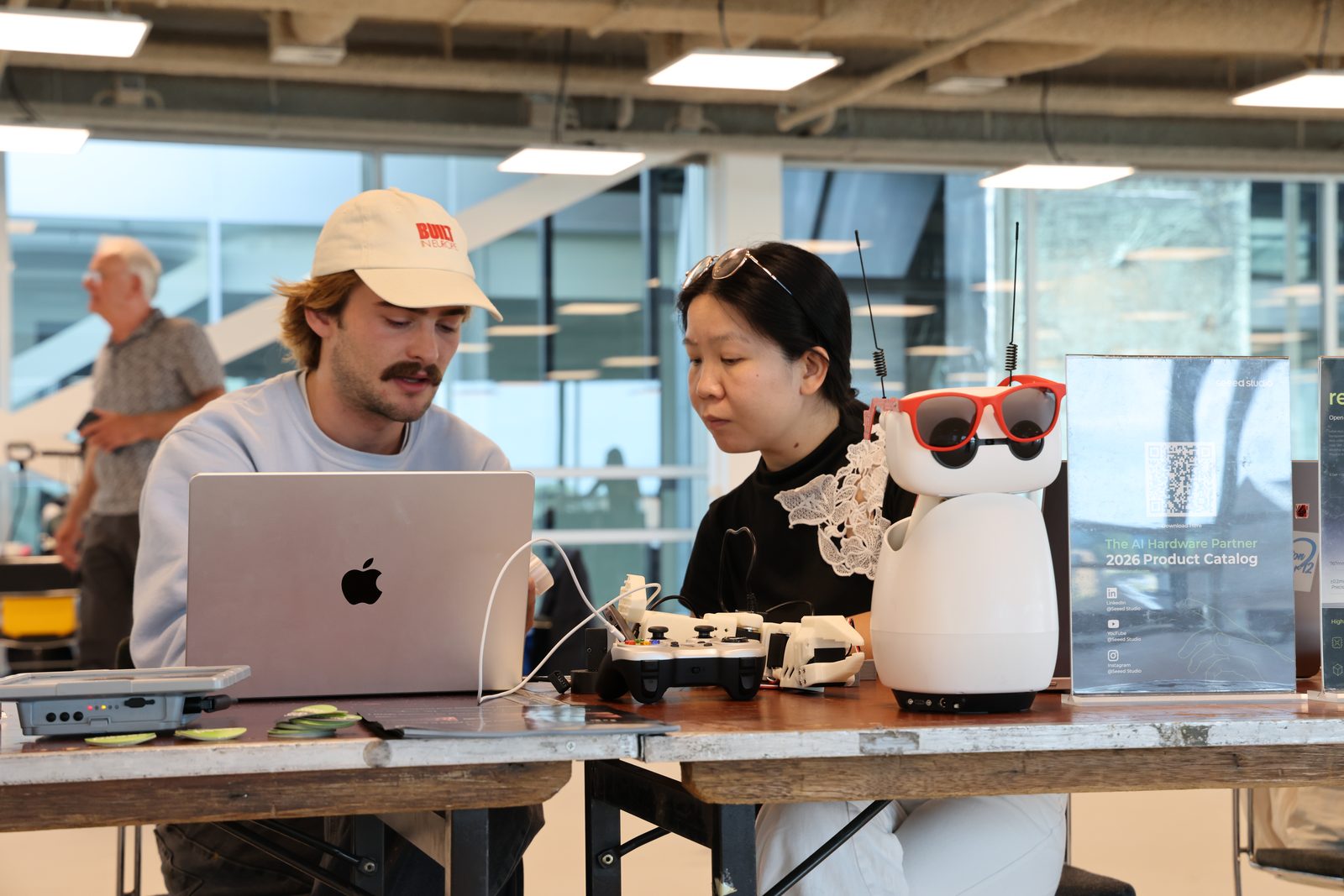 Gustav and Yu Wang at the Atech table with a robot and the laptop