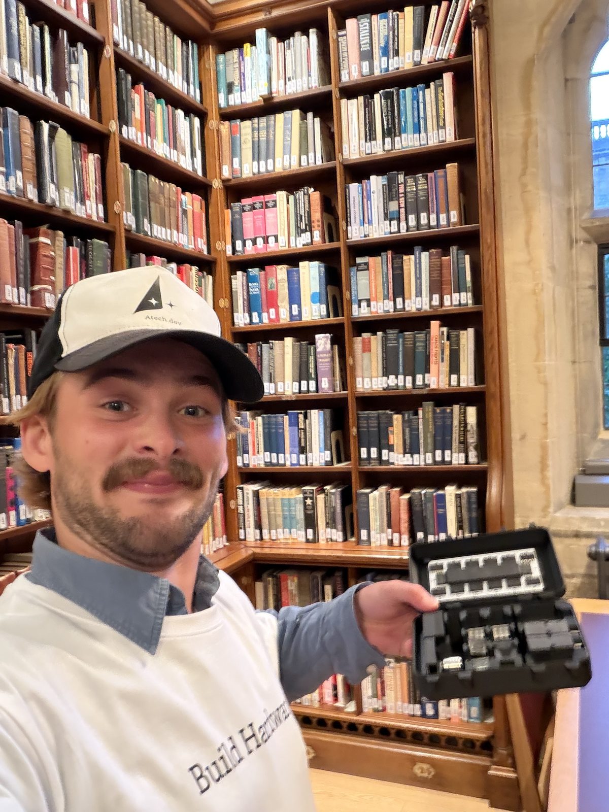 Gustav in a college library holding a kit