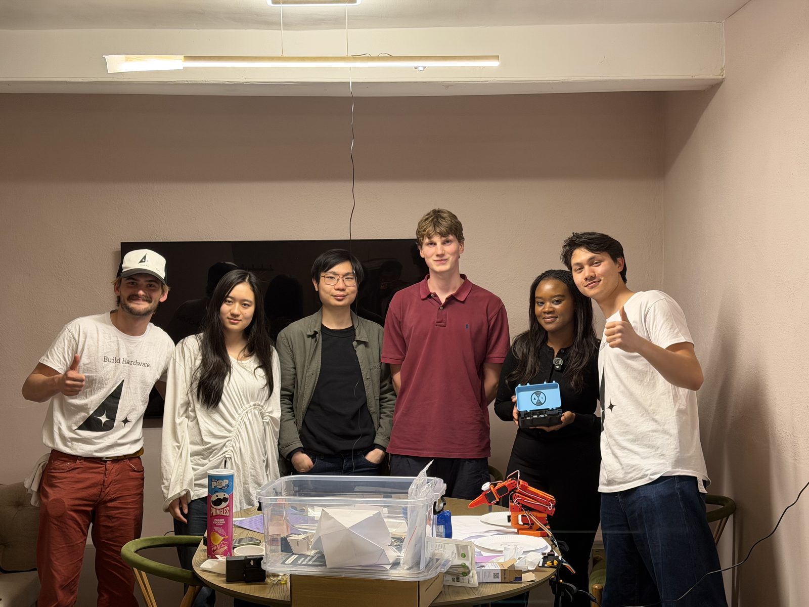 A team with their build, thumbs up, in the hack room