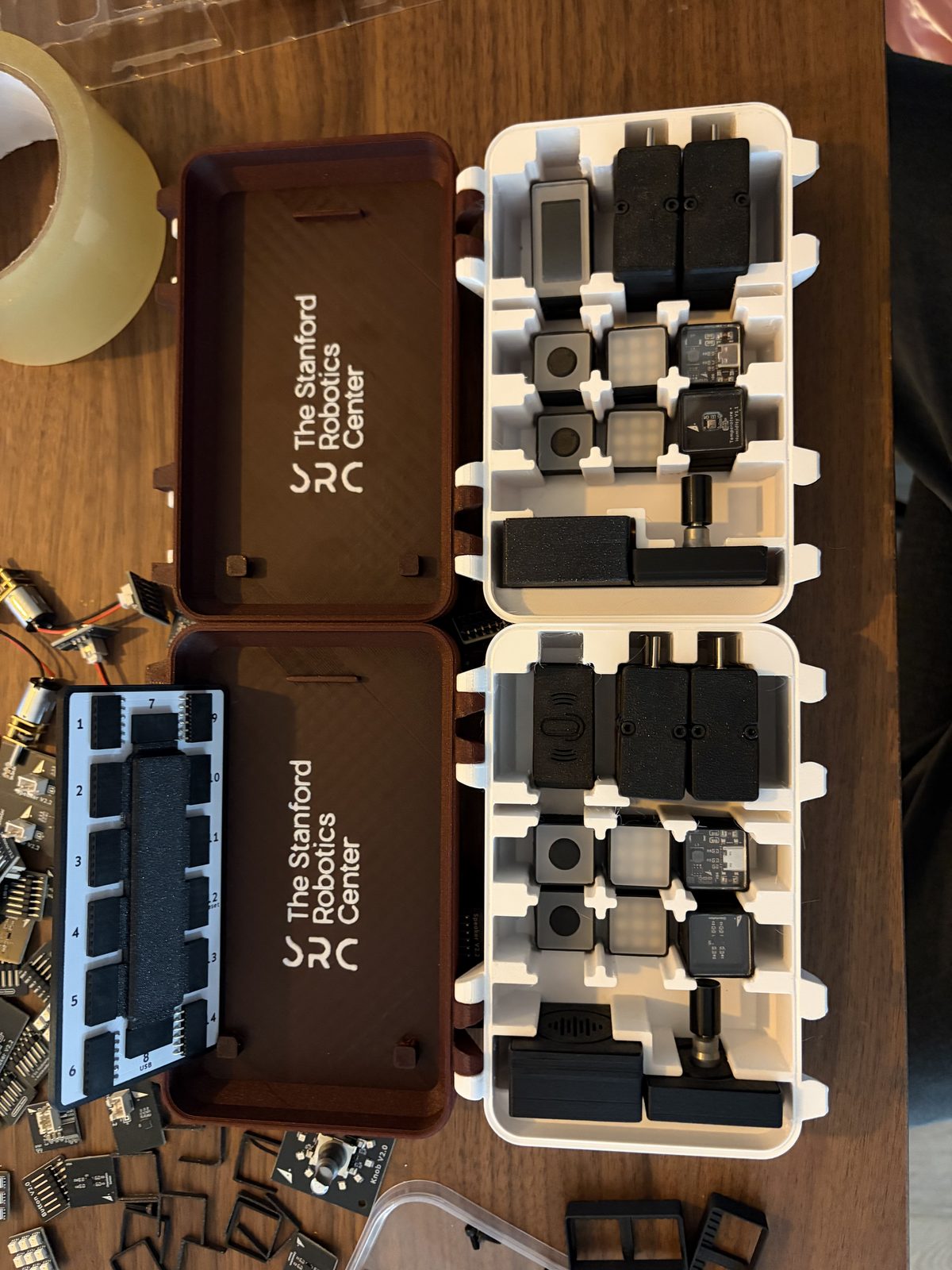 Two open custom kit cases engraved The Stanford Robotics Center, modules in white foam